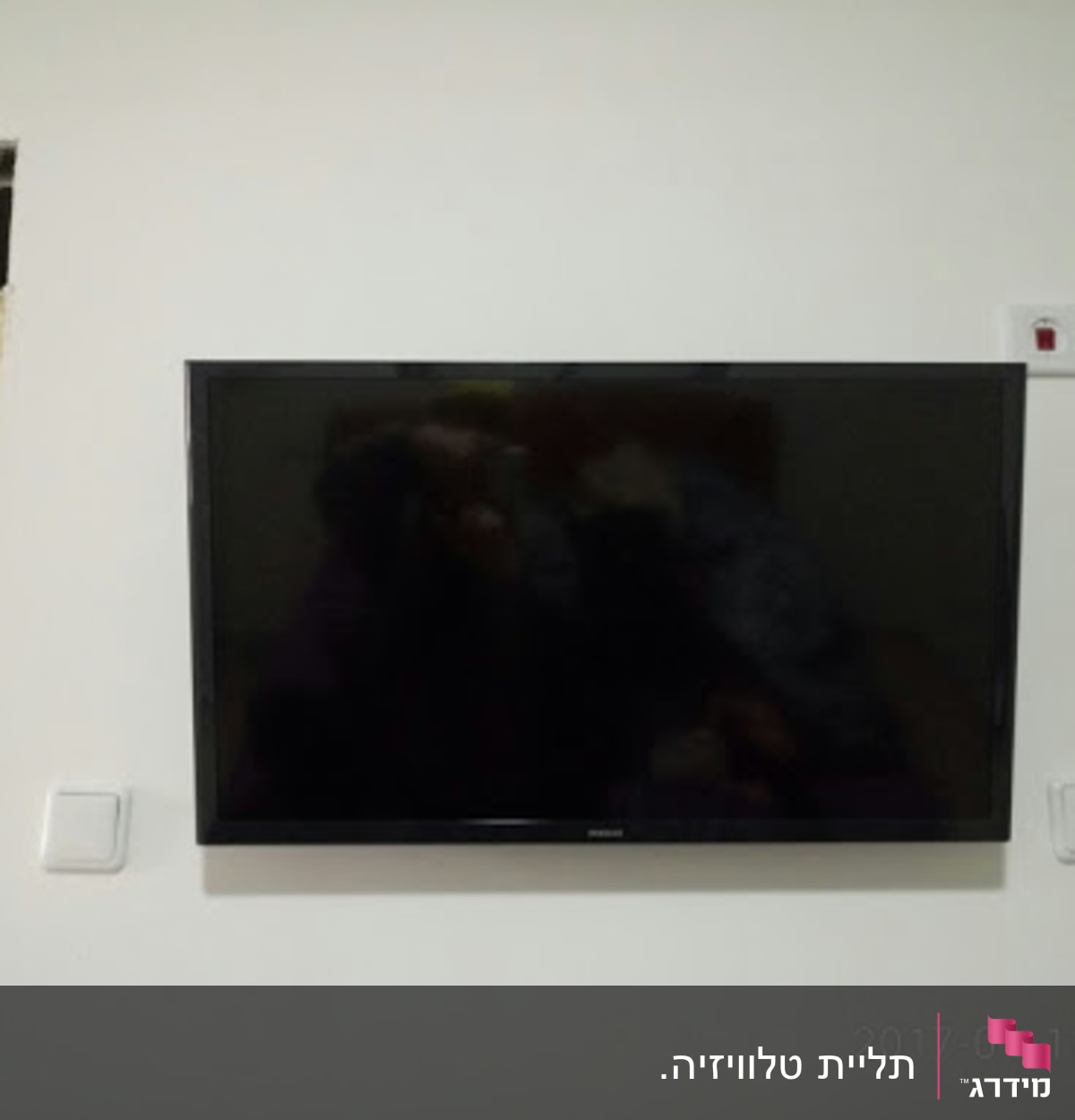 טלוויזיה מותקנת על קיר עם מתגי חשמל